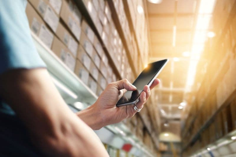 man uses cell phone in a large commercial building